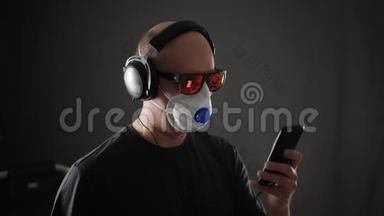人戴防护面罩听<strong>手机音乐</strong>.. 戴着安全面具的人听着耳机里的音乐
